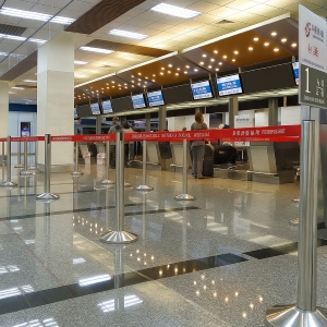 機場報到櫃檯前設置紅帶排隊柱，引導人流動線