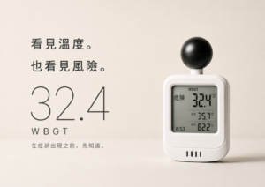 一台白色的日本 DRETEC 黑球式熱中症指數計置於米色背景中，頂部帶有黑色圓球輻射感測器。螢幕顯示綜合溫度熱指數 (WBGT) 為 32.4°C，左側標註「危險」，下方顯示氣溫 35.7°C、濕度 82.2% 與時間 15:53。左側搭配大字體「32.4 WBGT」與繁體中文文宣「看見溫度。也看見風險。在症狀出現之